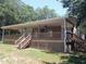 Charming house featuring a large covered porch and natural wood accents, set in a serene, wooded environment at 393 W Freeman St, Maysville, GA 30058