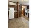 Functional kitchen with wood cabinets, tile flooring, and essential appliances at 393 W Freeman St, Maysville, GA 30058