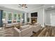 Bright living room with large windows, a stone fireplace, and comfortable seating, offering a relaxing atmosphere at 1618 Chancery Ln, Lithia Springs, GA 30122