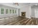 Spacious living room with a cozy stone fireplace, large windows, and hardwood floors at 1618 Chancery Ln, Lithia Springs, GA 30122