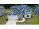 Aerial view showcasing a two-story house with landscaping, driveway, and a two-car garage at 4234 Freight St, Tucker, GA 30084