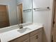 Bright bathroom with a single sink vanity, a large mirror, and a shower at 4234 Freight St, Tucker, GA 30084