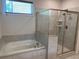 Bathroom featuring a glass shower and a large soaking tub with tile surround at 4234 Freight St, Tucker, GA 30084