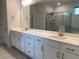 Bathroom featuring double sinks, a large mirror, and a glass-enclosed shower at 4234 Freight St, Tucker, GA 30084