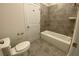 Bathroom features modern fixtures, gray tile, a tub and a toilet at 4234 Freight St, Tucker, GA 30084