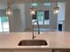 Modern kitchen with white cabinets, stainless steel faucet, and island sink overlooking living area at 4234 Freight St, Tucker, GA 30084