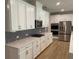 Kitchen featuring white cabinets, granite countertops, stainless appliances, and tile backsplash at 4234 Freight St, Tucker, GA 30084