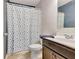 A full bathroom with a shower, toilet, dark colored vanity and blue accent wall at 529 Dasheill Ln, Atlanta, GA 30349