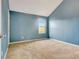 A bedroom with neutral colored carpet, a window, and freshly painted blue walls at 529 Dasheill Ln, Atlanta, GA 30349