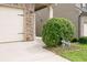 Close-up of garage door with stone accent, small bush with a bike decoration on the lawn at 529 Dasheill Ln, Atlanta, GA 30349