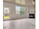 Bright living room with fireplace, ceiling fan, and view of the backyard through a large window and glass door at 529 Dasheill Ln, Atlanta, GA 30349