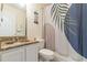 Functional bathroom featuring a granite vanity, toilet, and shower with patterned curtain at 970 Sidney Marcus Blvd # 1217, Atlanta, GA 30324