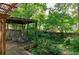 View of a backyard deck and swing, surrounded by lush greenery and a wooden fence at 2866 Wynford Sw Dr, Marietta, GA 30064