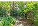 A quaint backyard with mature trees features lush greenery, a stone pathway and swing at 2866 Wynford Sw Dr, Marietta, GA 30064
