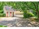Two-car garage with driveway, partial view of the house, and lush landscaping at 2866 Wynford Sw Dr, Marietta, GA 30064