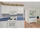 Kitchen with white appliances, cabinetry, blue countertops and pass-through to another room at 2866 Wynford Sw Dr, Marietta, GA 30064