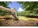 Expansive backyard featuring lush greenery, a wooden deck with stairs, and a well-maintained lawn for outdoor enjoyment at 629 Pine Ter, Canton, GA 30114