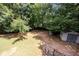 Private backyard featuring mature trees, a storage shed, and a well-maintained lawn, creating a serene outdoor space at 629 Pine Ter, Canton, GA 30114