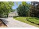 Long driveway leading to a three-car garage, surrounded by well-maintained lawn and trees at 629 Pine Ter, Canton, GA 30114