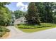 Exterior view featuring a long driveway surrounded by landscaping and large trees at 629 Pine Ter, Canton, GA 30114
