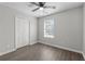 A bright bedroom features a window, ceiling fan, and double closet at 425 Orchard Dr, Stone Mountain, GA 30083
