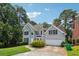 Two-story home with a well-manicured lawn, lush greenery, and attached garage at 4467 Boatmans Cv, Stone Mountain, GA 30083