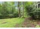 The landscaped backyard offers a firepit, lounge chairs, a creek and serene wooded views at 2200 Major Loring Sw Way, Marietta, GA 30064