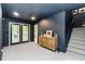 Finished basement featuring dark wall paint, carpeted floors, staircase and door to the backyard at 2200 Major Loring Sw Way, Marietta, GA 30064