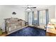 Comfortable Bedroom featuring a crib, large windows, and hardwood floors with area rug at 2200 Major Loring Sw Way, Marietta, GA 30064