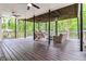 Spacious covered deck featuring outdoor furniture, a swing, ceiling fans, and views of the surrounding greenery at 2200 Major Loring Sw Way, Marietta, GA 30064