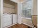 Convenient laundry room with washer, dryer, shelving, and natural light from a window at 734 Celeste Sw Ln # 84, Atlanta, GA 30331