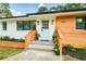Charming home exterior boasts updated wood and brick features, well-maintained landscaping, and inviting curb appeal at 1048 Pinehurst Se Dr, Smyrna, GA 30080