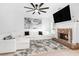 Bright living room with fireplace, white sofa, large TV, ceiling fan, and stylish decor at 2100 Lily Valley Dr, Lawrenceville, GA 30045