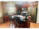 The kitchen features wood cabinets, stainless steel appliances, granite countertops, and a central island with bar stools at 2545 Melville Pl, Powder Springs, GA 30127
