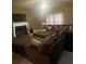 Inviting living room features a fireplace, a large brown sectional couch, and soft natural light coming through the windows at 2545 Melville Pl, Powder Springs, GA 30127