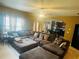 Cozy living room with a large sectional sofa, ceiling fan, and natural light, seamlessly connecting to the dining and kitchen areas at 2545 Melville Pl, Powder Springs, GA 30127