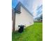 Side yard view with grass and a trash can near the siding of a house on a sunny day at 2545 Melville Pl, Powder Springs, GA 30127