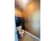 Powder room featuring metallic gold wallpaper and storage cabinet above the toilet at 2545 Melville Pl, Powder Springs, GA 30127