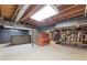 Spacious unfinished basement featuring exposed beams, bar area, piano, and stairs at 357 W Hightower Trl, Social Circle, GA 30025