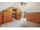 Bedroom with knotty pine walls, neutral carpet, and multiple closets or storage spaces at 357 W Hightower Trl, Social Circle, GA 30025