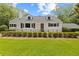 Charming home featuring a white exterior, landscaped yard, and a covered parking area at 357 W Hightower Trl, Social Circle, GA 30025