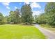 Large, well-maintained front yard with mature trees and a driveway leading to the home at 357 W Hightower Trl, Social Circle, GA 30025