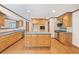 Spacious kitchen features custom wood cabinets, large center island, hardwood floors, and stainless steel appliances at 357 W Hightower Trl, Social Circle, GA 30025