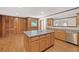 Kitchen with wood cabinets, island and hardwood floors offer a warm space for culinary creations and gatherings at 357 W Hightower Trl, Social Circle, GA 30025