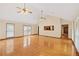 Bright living room features hardwood floors, large windows, and a view into the kitchen, offering open-concept living at 357 W Hightower Trl, Social Circle, GA 30025