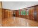 Inviting living room features hardwood floors, large windows, and classic wood paneling for a warm ambiance at 357 W Hightower Trl, Social Circle, GA 30025