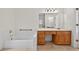 Well-lit bathroom with tiled floor, vanity, bathtub and gold hardware at 2000 Stockton Walk Ln, Snellville, GA 30078