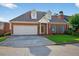 Inviting brick home showcases dormer windows, an attached garage, and a neatly landscaped front yard at 2000 Stockton Walk Ln, Snellville, GA 30078