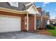 Classic brick home offering a two-car garage, welcoming front porch, and verdant landscaping at 2000 Stockton Walk Ln, Snellville, GA 30078
