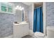 Stylish bathroom with blue patterned wallpaper, a white vanity, and a shower with a blue curtain at 4291 Lamar Street St, Decatur, GA 30035